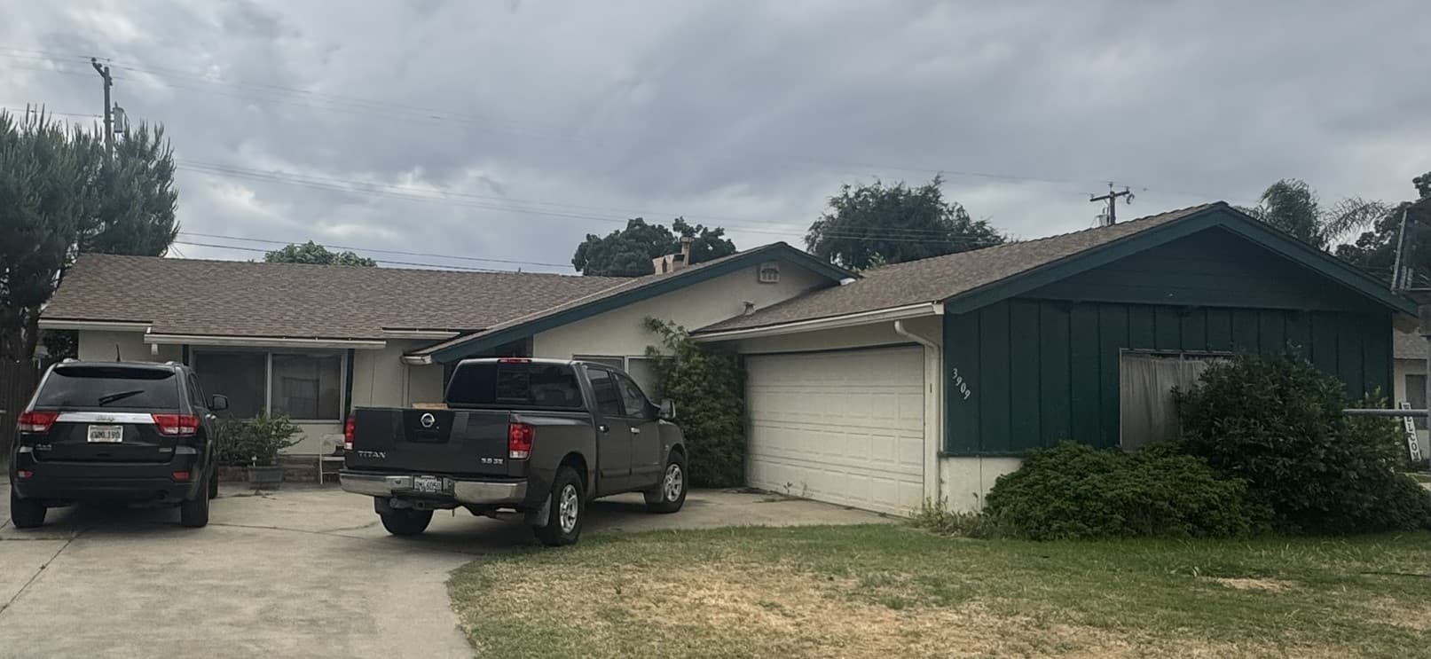Occupied California rental duplex with cars out front and belongings on the porch